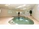 Beautiful indoor pool with attached hot tub, multiple windows, and recessed lighting at 3428 Longleaf Rd, Ormond Beach, FL 32174
