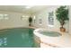 View of the large indoor pool and hot tub, featuring natural light and tiled accents at 3428 Longleaf Rd, Ormond Beach, FL 32174