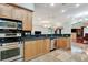 Open kitchen with stainless steel appliances, wood cabinets, and black granite countertops at 3428 Longleaf Rd, Ormond Beach, FL 32174