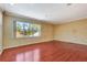Well-lit living room with hardwood floors and a large window overlooking lush greenery at 3428 Longleaf Rd, Ormond Beach, FL 32174