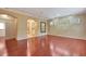 Open-concept living room with hardwood floors, arched doorway, and a decorative mirror at 3428 Longleaf Rd, Ormond Beach, FL 32174