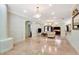 Spacious living room with marble floors, crystal chandeliers, and views of the kitchen and sunroom at 3428 Longleaf Rd, Ormond Beach, FL 32174