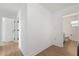 Hallway with a view to the bathroom, light wood floors, and white walls at 3655 Scott St, Port Orange, FL 32129