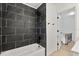 Bathroom shower featuring modern dark tile and white trim, with hallway access at 3655 Scott St, Port Orange, FL 32129