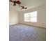 Carpeted bedroom with a ceiling fan and natural light streaming through a window at 405 Carina Cir, Sanford, FL 32773