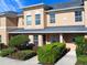 Inviting two-story townhome with lush landscaping, neutral paint, and a covered entryway at 405 Carina Cir, Sanford, FL 32773