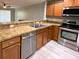 Kitchen featuring stainless steel appliances, wood cabinets, and neutral countertops at 405 Carina Cir, Sanford, FL 32773