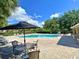Enjoy the community pool with a brick patio and plentiful seating for relaxing under the Florida sunshine at 405 Carina Cir, Sanford, FL 32773