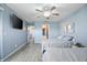 Spacious bedroom with tile floors, light blue walls, ceiling fan, and a large flatscreen television at 4403 Sea Mist Dr # 2110, New Smyrna Beach, FL 32169