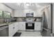 Well-equipped kitchen featuring stainless steel appliances, white cabinets, and granite countertops at 4403 Sea Mist Dr # 2110, New Smyrna Beach, FL 32169