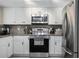 Modern kitchen with stainless steel appliances, sleek white cabinets, and stylish tile backsplash at 4403 Sea Mist Dr # 2110, New Smyrna Beach, FL 32169