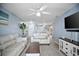 Bright living room with modern furnishings, light wood floors, ceiling fan, and a view of the kitchen at 4403 Sea Mist Dr # 2110, New Smyrna Beach, FL 32169