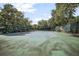 View of the community's tennis court, surrounded by mature trees, offering a private recreational space at 4403 Sea Mist Dr # 2110, New Smyrna Beach, FL 32169