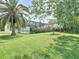 Spacious backyard featuring a palm tree, verdant lawn, and screened lanai at 456 Sea Duck Dr, Daytona Beach, FL 32119