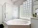 Bright bathroom features a soaking tub and glass block window for privacy and natural light at 456 Sea Duck Dr, Daytona Beach, FL 32119
