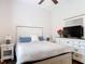 Bright bedroom features a queen-sized bed, dresser with a TV, and a ceiling fan at 456 Sea Duck Dr, Daytona Beach, FL 32119