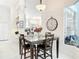 Dining room with dark wood table and seating, large clock, and view to the kitchen and bar area at 456 Sea Duck Dr, Daytona Beach, FL 32119