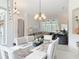 Bright dining room with modern chandelier, large windows, and open floor plan to living area at 456 Sea Duck Dr, Daytona Beach, FL 32119