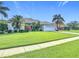 Inviting single-story home featuring a lush green lawn and tropical landscaping at 456 Sea Duck Dr, Daytona Beach, FL 32119