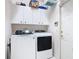 Functional laundry room with washer, dryer, and overhead cabinets for storage at 456 Sea Duck Dr, Daytona Beach, FL 32119