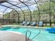 Beautiful in-ground pool with screened enclosure and a jacuzzi and poolside lounge chairs at 456 Sea Duck Dr, Daytona Beach, FL 32119