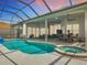 Screened-in pool with attached spa, covered patio, ceiling fans, and ample seating, perfect for relaxation at 456 Sea Duck Dr, Daytona Beach, FL 32119