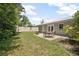 Spacious backyard featuring a well-manicured lawn, a cozy patio with a fire pit, and lush landscaping at 502 W Hogle Ave, Deland, FL 32720