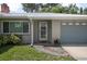 Inviting front entrance with stone walkway, a gray garage door, and colorful flower pots at 502 W Hogle Ave, Deland, FL 32720