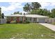 Charming single-story home with a well-manicured lawn, brick accents, and a metal roof at 502 W Hogle Ave, Deland, FL 32720