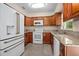 Well-equipped kitchen featuring granite countertops, wood cabinets, and modern white appliances at 502 W Hogle Ave, Deland, FL 32720