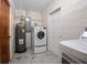 Utility room with front loading washer and dryer, utility sink, and hot water heater at 502 W Hogle Ave, Deland, FL 32720