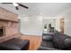 Open living room with hardwood floors, a brick fireplace, and views of the dining area at 502 W Hogle Ave, Deland, FL 32720