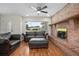 Bright living room with brick fireplace, a large window, and comfortable leather seating at 502 W Hogle Ave, Deland, FL 32720