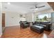 Spacious living room with hardwood floors, a ceiling fan, and large windows for natural light at 502 W Hogle Ave, Deland, FL 32720