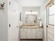 Well-lit bathroom with a granite countertop vanity, multiple mirrors, and a white paneled door at 505 Black Ironwood Dr, Deland, FL 32724