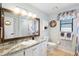 Bathroom featuring a wood-trimmed mirror, granite countertop, and a seashell-themed wreath at 505 Black Ironwood Dr, Deland, FL 32724