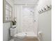 Modern bathroom featuring a white tiled shower, rainfall showerhead, and stylish decor at 505 Black Ironwood Dr, Deland, FL 32724