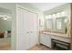 Bright bathroom with double mirrors, granite countertop vanity, and stylish bifold closet doors at 505 Black Ironwood Dr, Deland, FL 32724