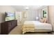 Cozy bedroom with a large TV, striped blanket, and a window offering natural light at 505 Black Ironwood Dr, Deland, FL 32724