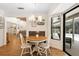 Charming dining area with a round table, white chairs, and a sliding glass door to the outdoor patio at 505 Black Ironwood Dr, Deland, FL 32724