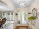 Bright foyer with a decorative light fixture, modern console table, and glass paneled front door at 505 Black Ironwood Dr, Deland, FL 32724