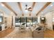 Bright living room with exposed wood beams, ceiling fan, and sliding glass doors to the pool area at 505 Black Ironwood Dr, Deland, FL 32724