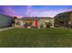 Charming home with a well-manicured lawn and a vibrant red front door at 505 Wisteria Rd, Daytona Beach, FL 32118