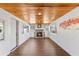 Spacious room boasts wood-paneled ceiling, wood floors, a stone fireplace, and plenty of windows at 505 Wisteria Rd, Daytona Beach, FL 32118