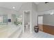 Bright bathroom featuring dual sinks, a glass shower, soaking tub, and wood floors at 519 Donaldson Dr, Debary, FL 32713