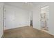 A well-lit bedroom features neutral carpet, white walls, and a doorway leading to the bathroom at 519 Donaldson Dr, Debary, FL 32713