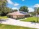 Charming single-story brick home with solar panels, a well-manicured lawn, and a spacious driveway, showcasing curb appeal at 519 Donaldson Dr, Debary, FL 32713