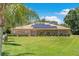 Charming brick home featuring a well-manicured lawn, complemented with solar panels for energy efficiency at 519 Donaldson Dr, Debary, FL 32713