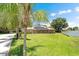 An attractive brick home with solar panels sits on a lush lawn, bordered by mature palm trees and shrubs at 519 Donaldson Dr, Debary, FL 32713
