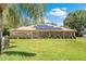 Charming brick home featuring a well-manicured lawn, complemented with solar panels for energy efficiency at 519 Donaldson Dr, Debary, FL 32713